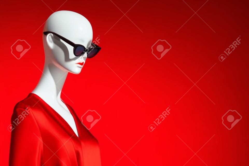 Retrato de maniquí femenino con gafas de sol y vestido rojo. Tema de venta y publicidad. Copyspace para texto