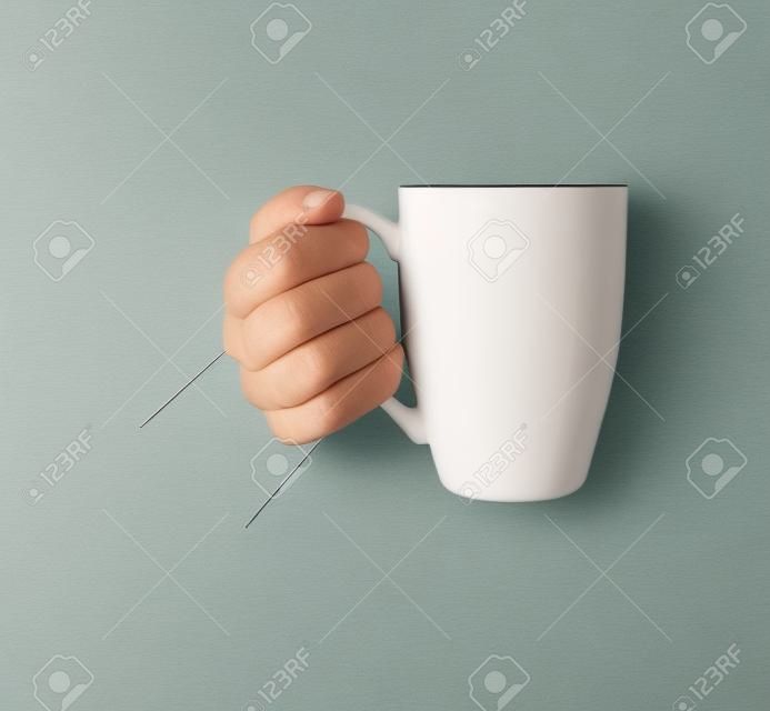 the girls hand is holding a mug. Side view.