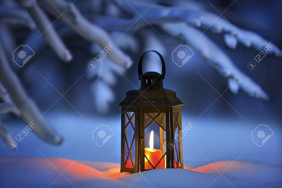 Candle lantern in snow at dusk