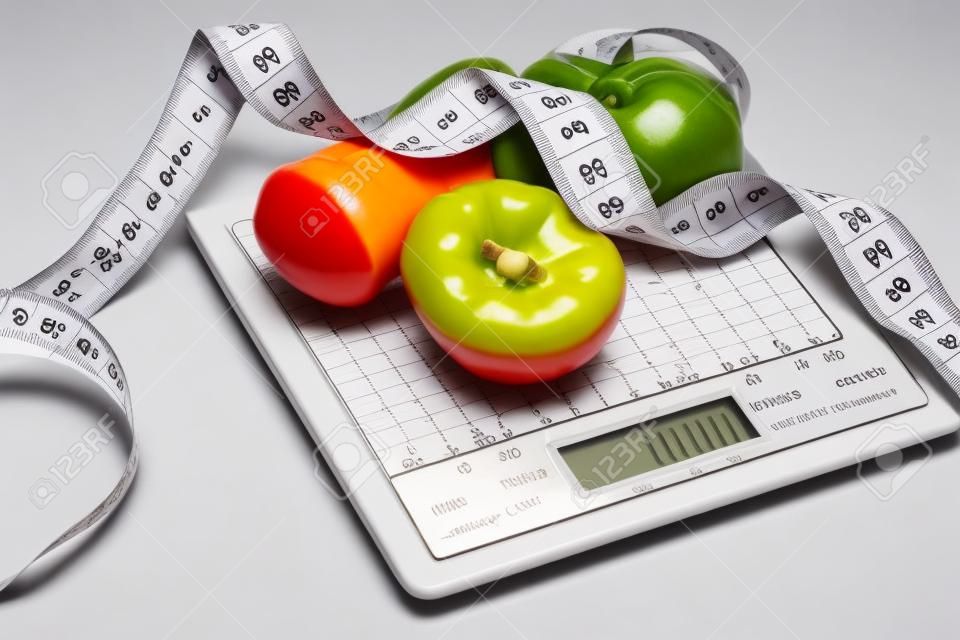 Diète. Fruits et légumes avec ruban à mesurer sur l'échelle de poids