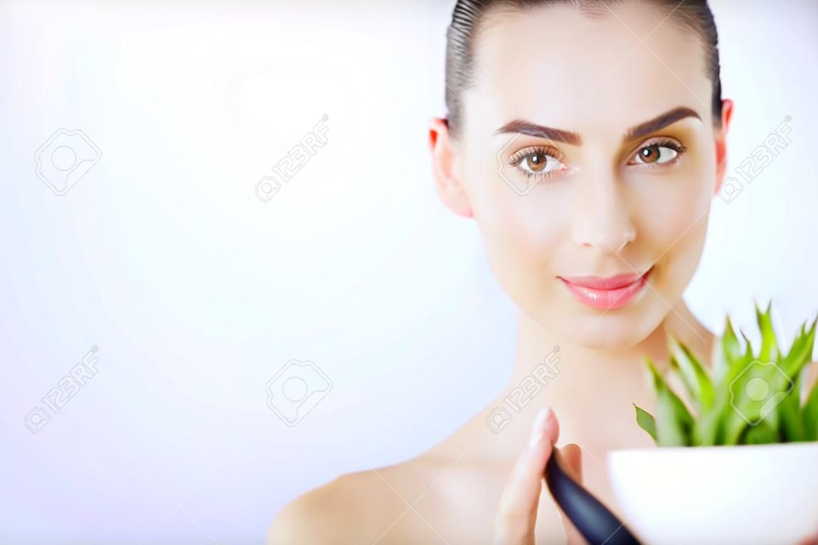Protección de la piel. Rostro de mujer de belleza con piel sana y planta verde