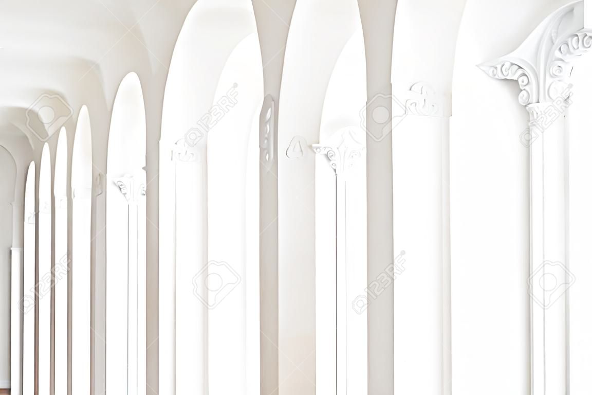 Interni di lusso costosi. Elementi in stucco sulla linea di colonne luminose. Fantasia bianca. Elemento modanature in gesso.