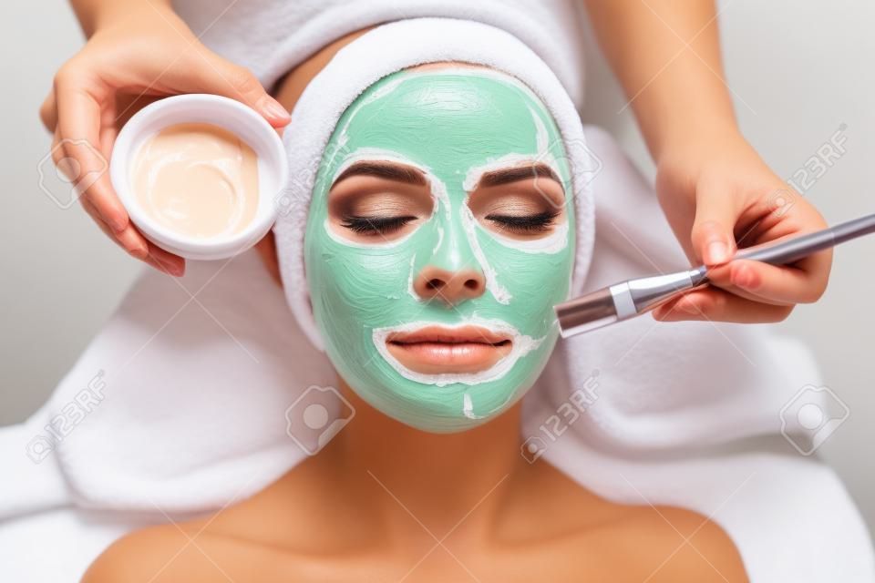 Close-up tiro de uma mulher recebendo tratamento facial com máscara de argila. Cosmetologia e spa