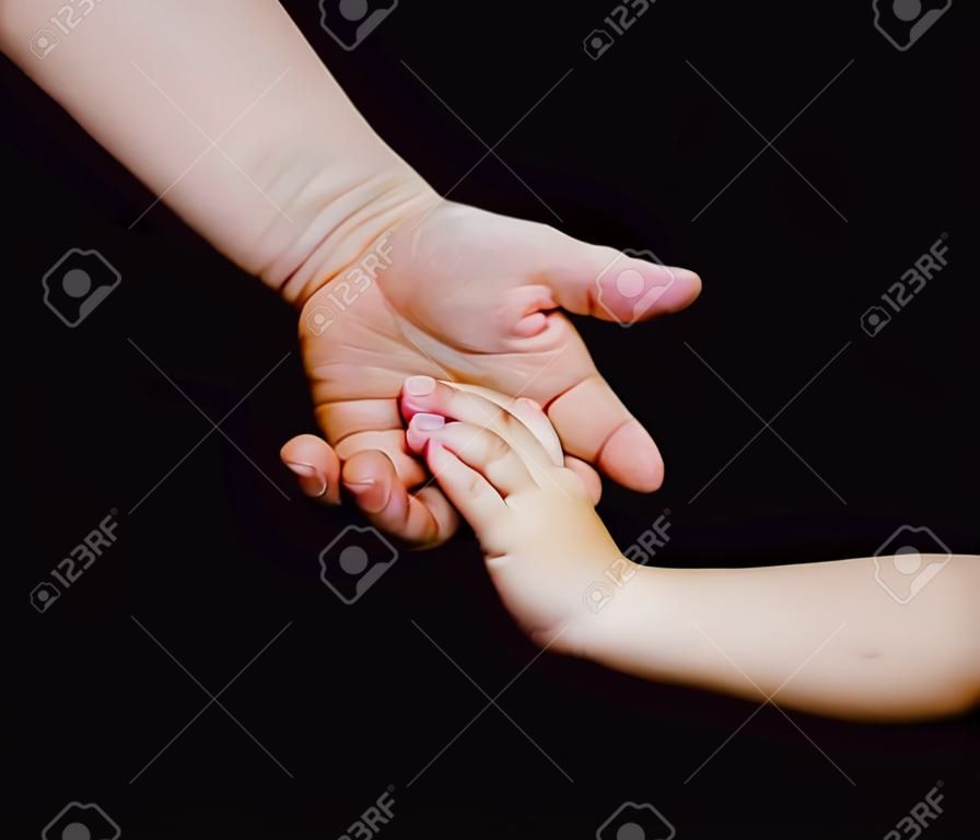 媽媽給手一個孩子在黑色的背景，手，家庭