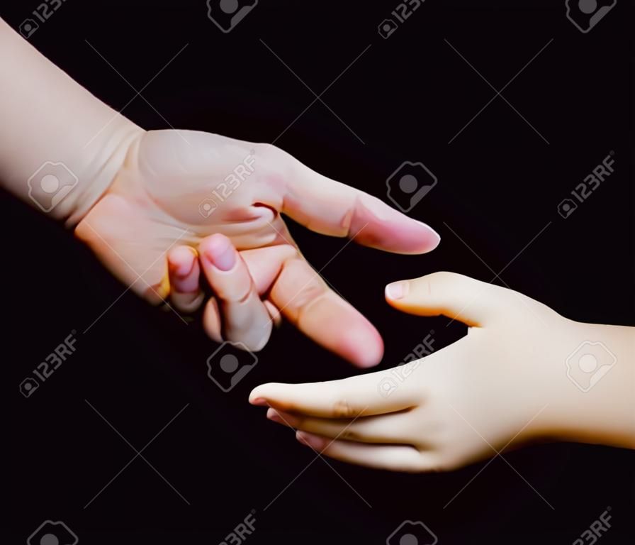 Mère donnant la main à un enfant sur fond noir, les mains, la famille