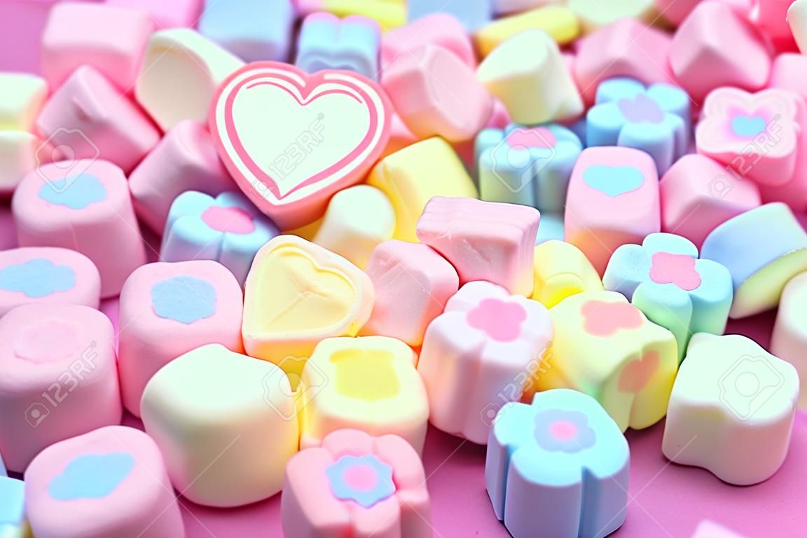 Selective focus, Close-up a bunch of colorful, pastel, sweet color of sweet candy marshmallows on the pink background for web banner, brochure, leaflet, flyer template design