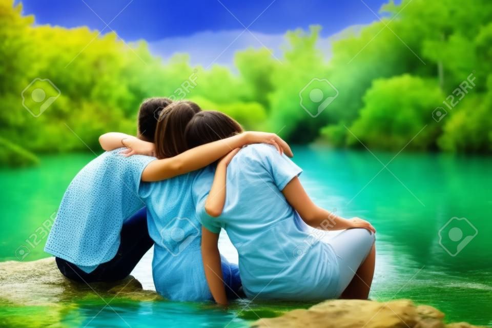 Amici che si abbracciano in un lago naturale in mezzo alla foresta.