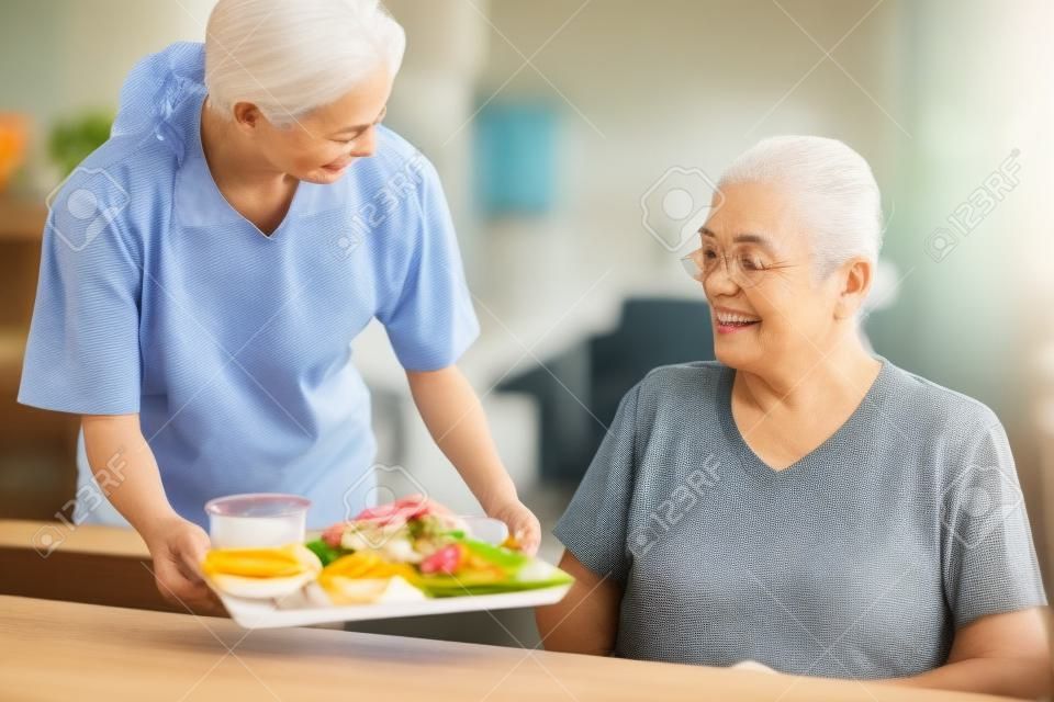 una badante che serve pasti agli anziani