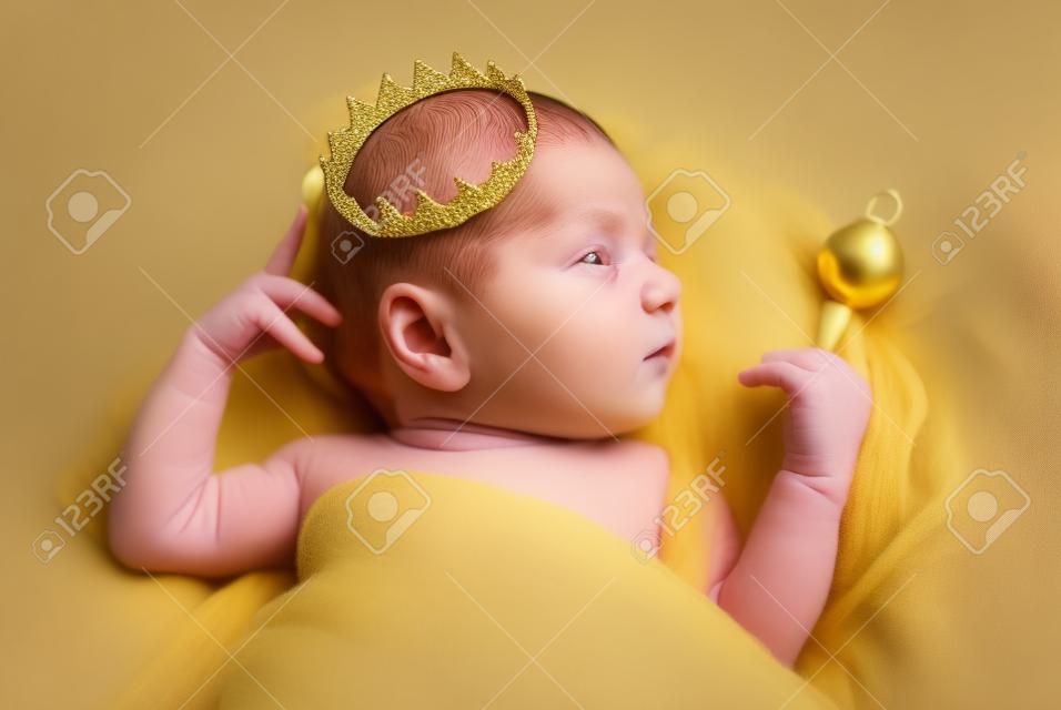 Portrait of a newborn baby boy with a golden crown