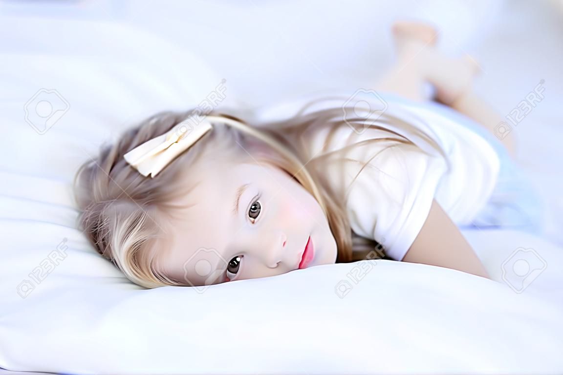 Sleepy niña linda acostado en la cama