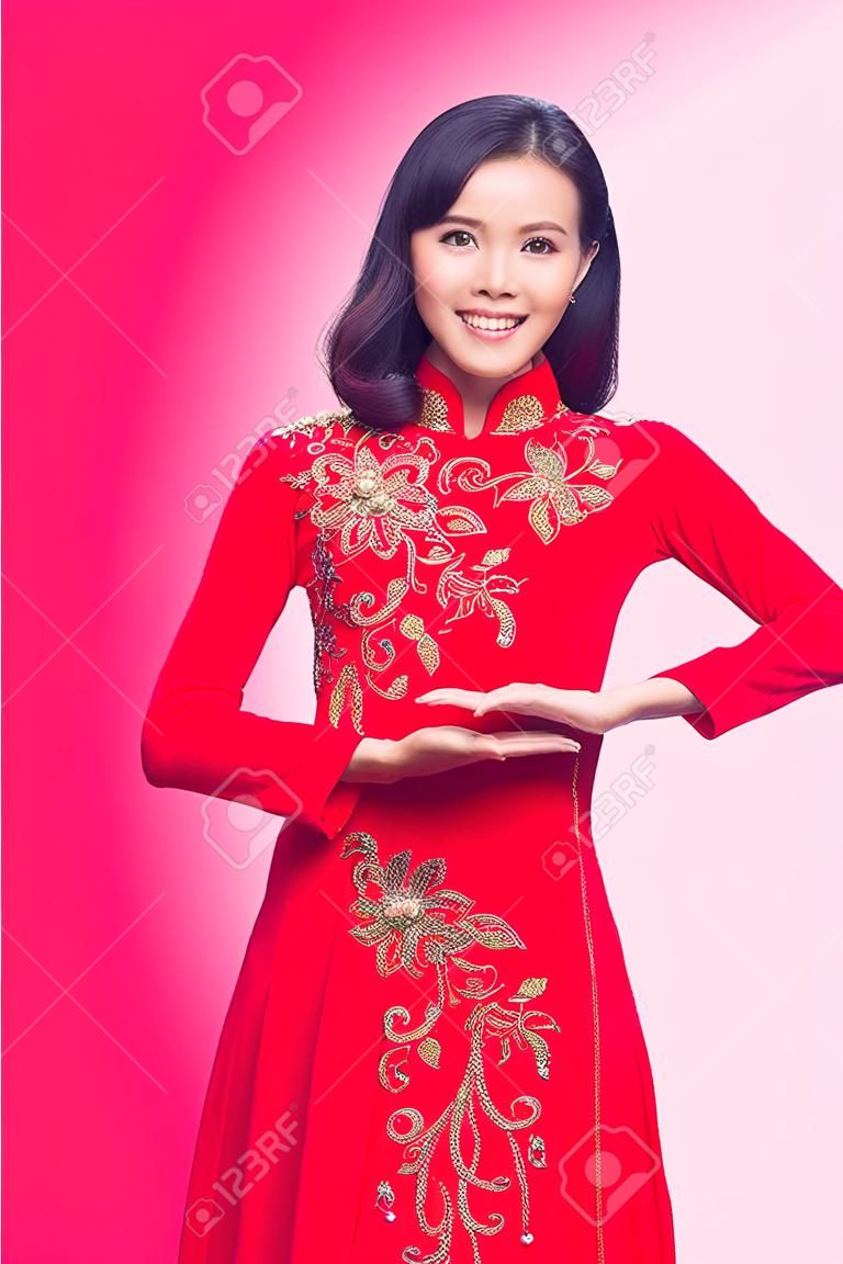Charming Vietnamese Woman in Red Ao Dai Traditional Dress Present Something.