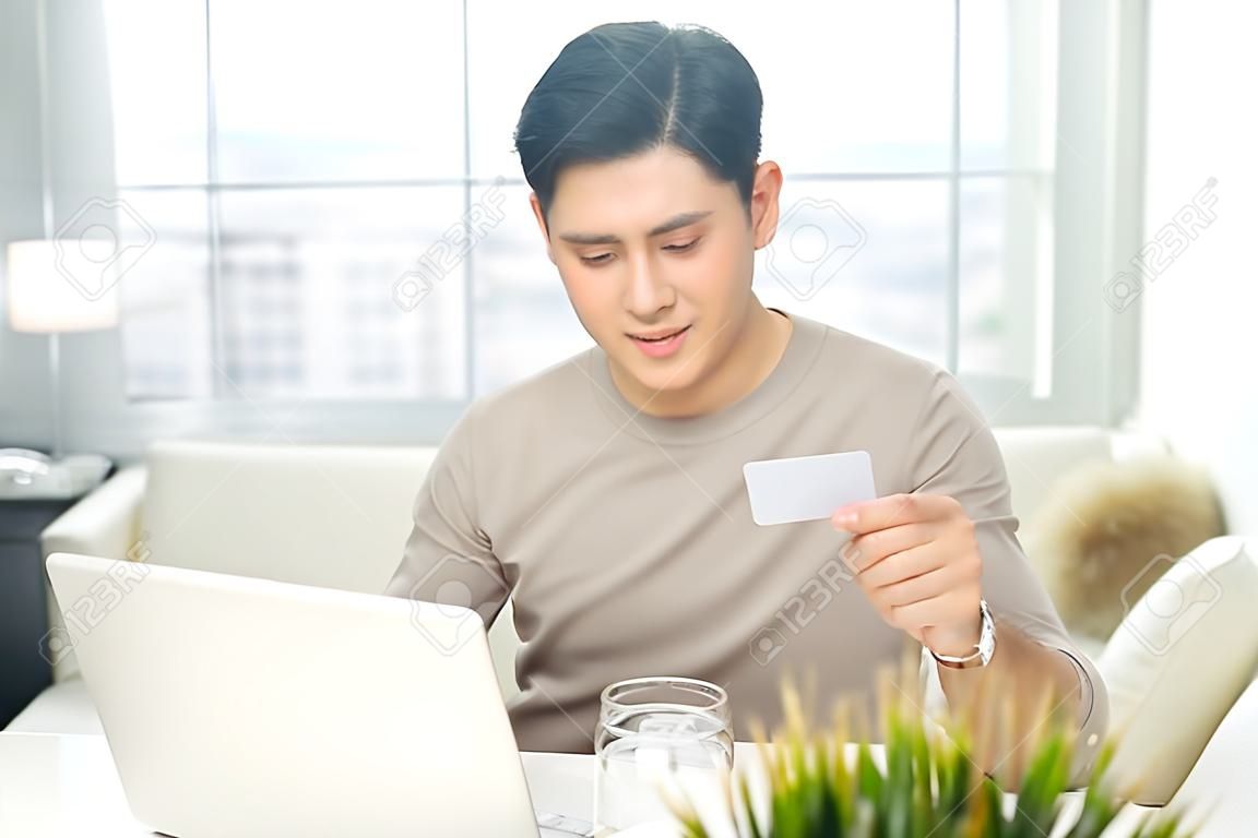 Portret dorywczo uśmiechnięty młody człowiek dokonać płatności za pomocą karty kredytowej