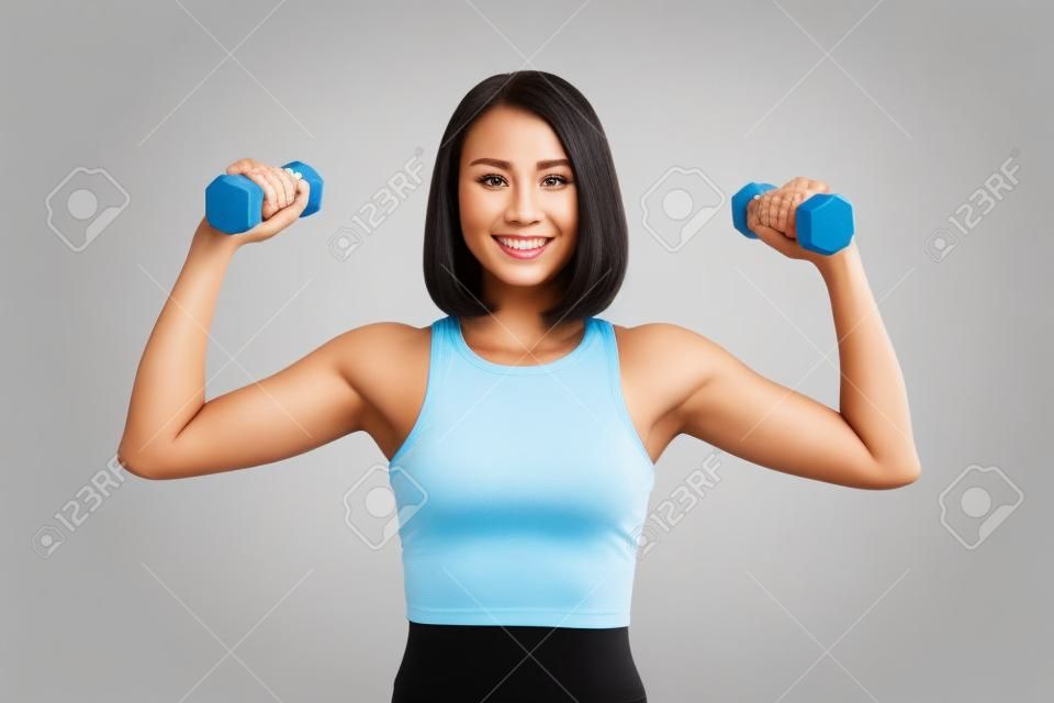 Woman is exercising with dumbbells