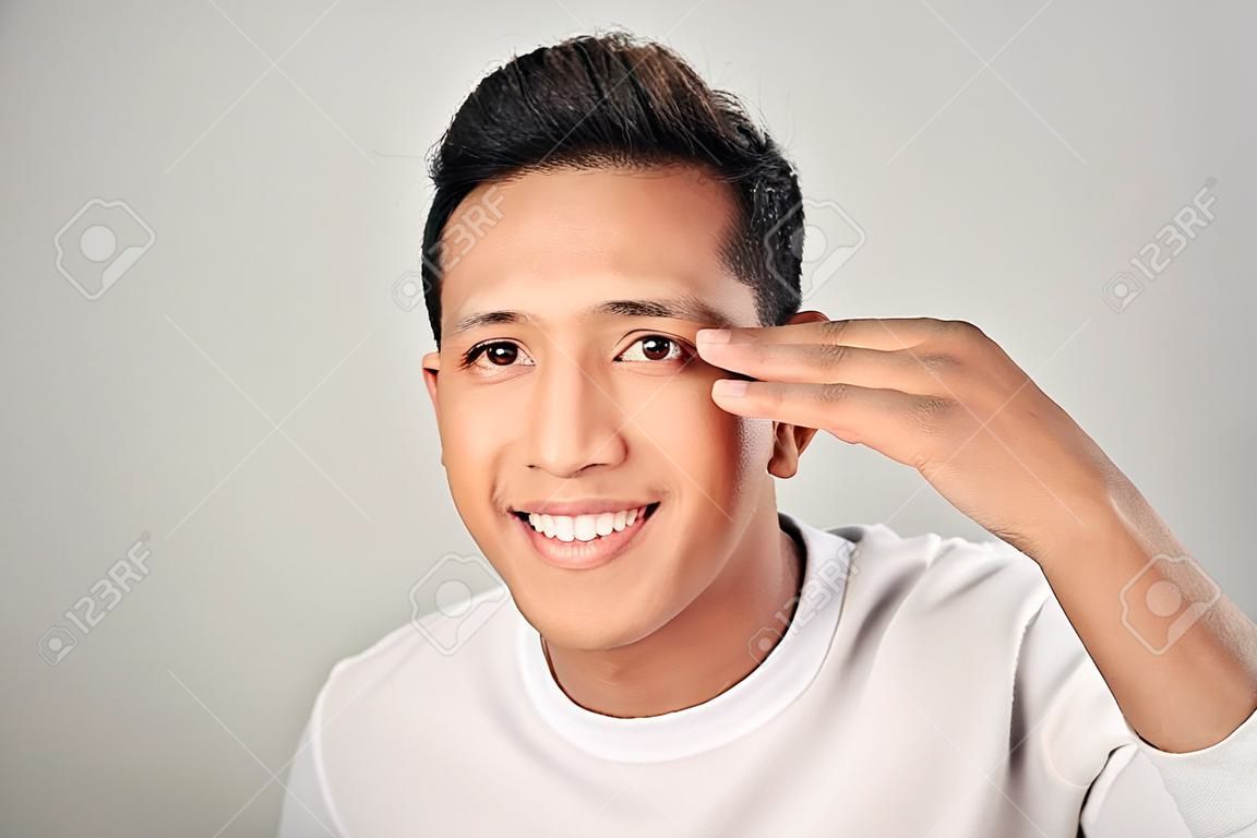 Handsome man touching his face close up portrait studio on white background