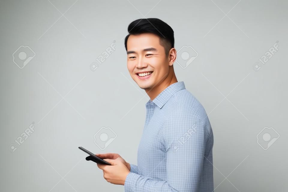 Happy smile face of handsome Asian man use smartphone.