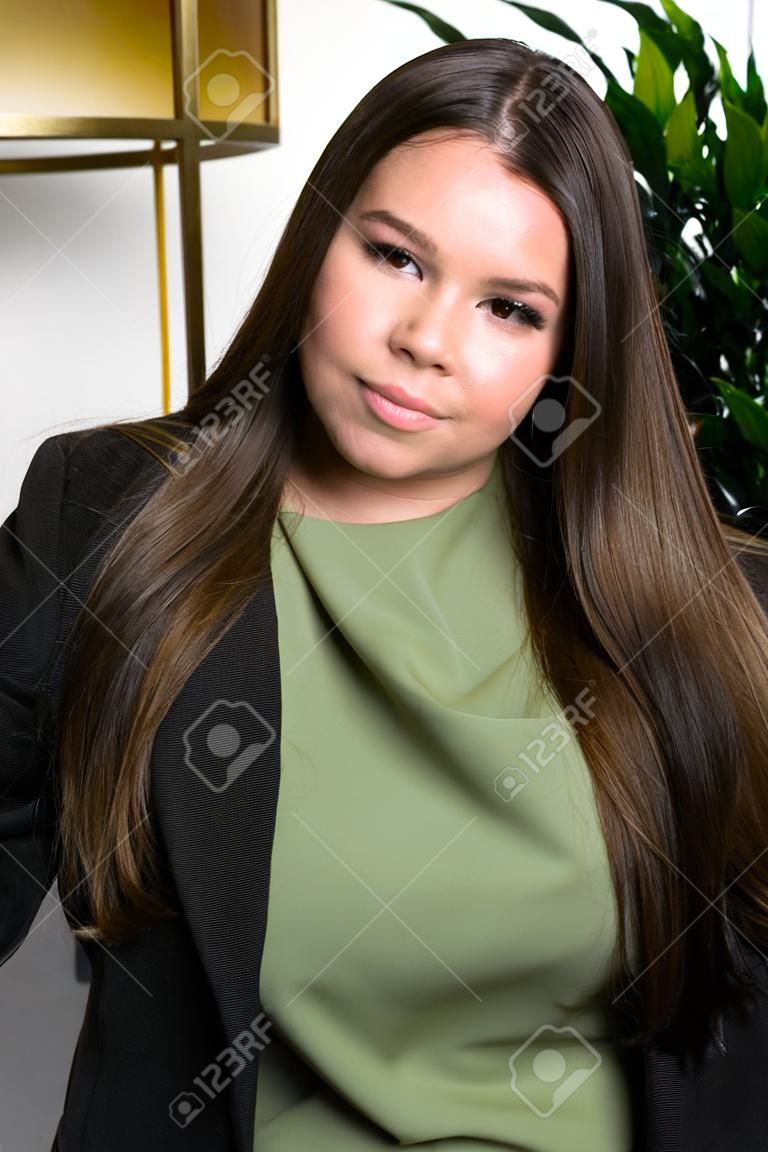 Close up portrait of young beautiful lady wearing stylish classic clothes posing at the studio. Plus size model. Female fashion concept