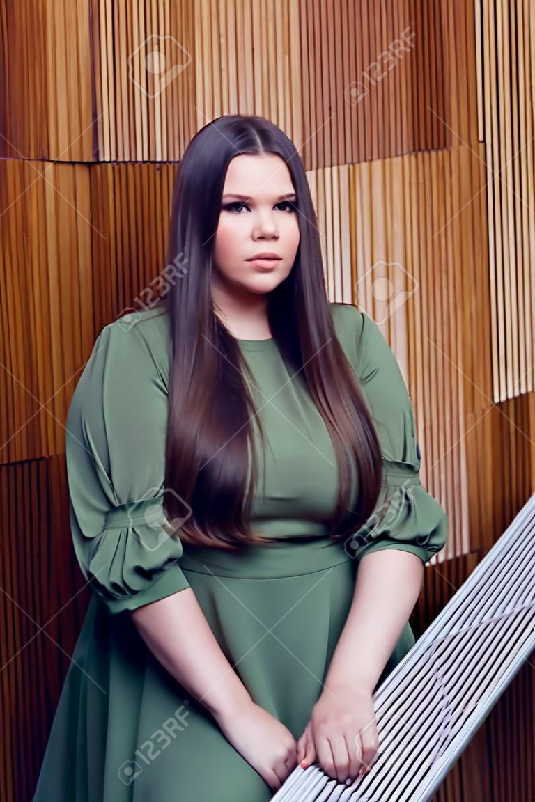 Plus size fashion model portrait with long brown hair. Glamour beautiful woman with healthy and beautiful hair