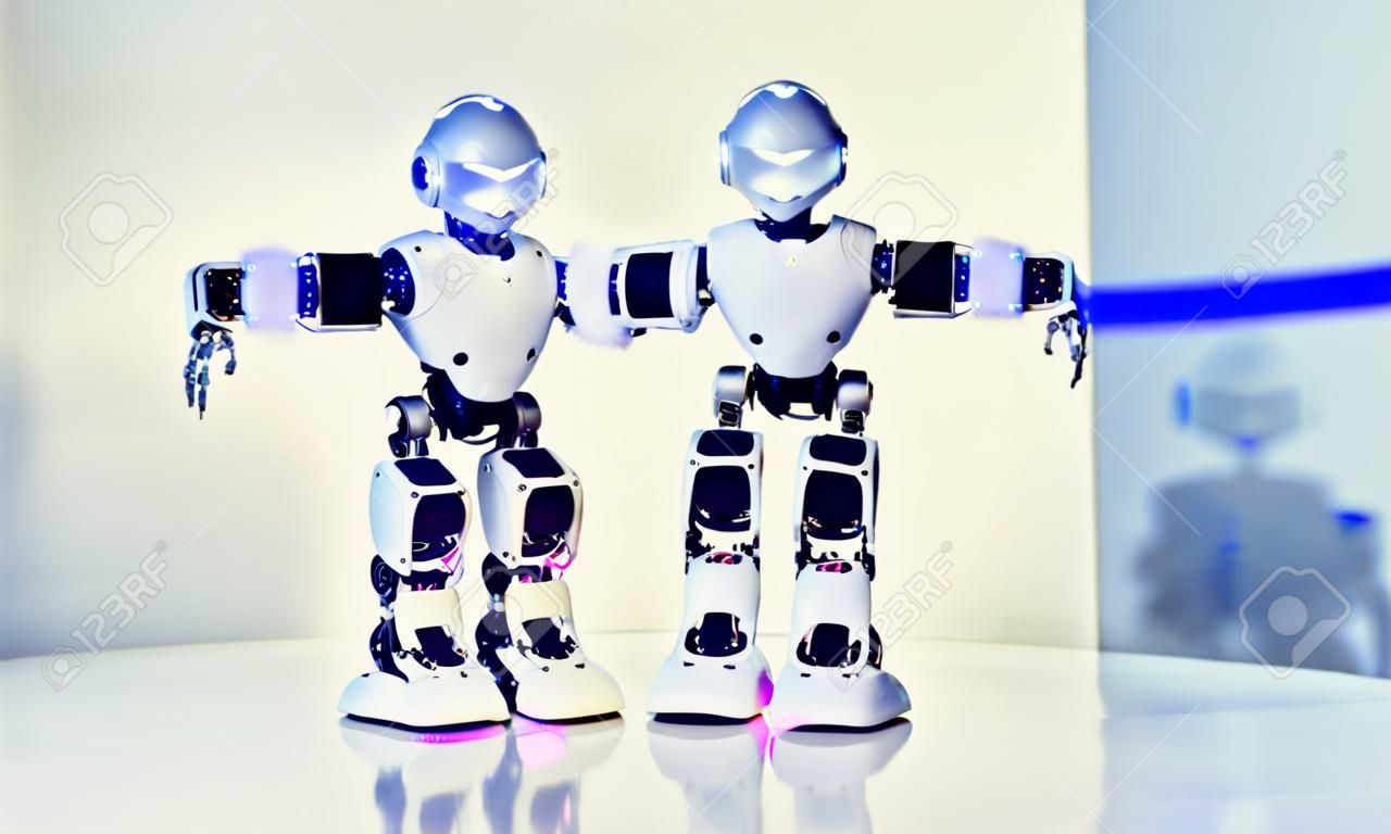 Kleine Cyborg Roboter, Humanoide mit Gesicht, leuchtende Augen, Körpertänze und macht verschiedene Bewegungen der Hände, Füße zur Musik. Künstliche Intelligenz. AI Smart Robot.Concept von 4.0 industrielle Revolution