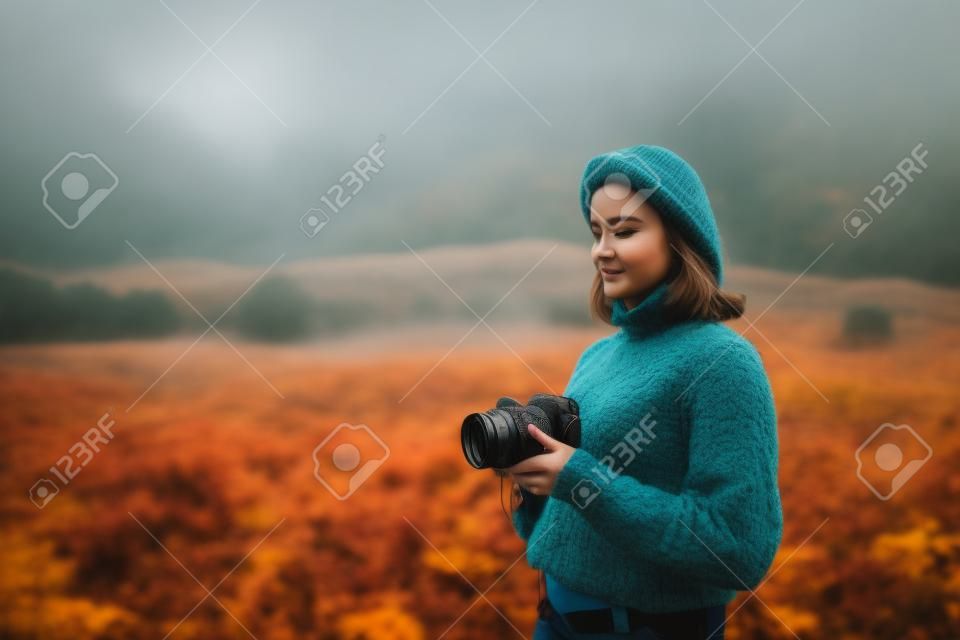 ragazza fotografo scatta foto sulla fotocamera su sfondo montagna rana autunnale, turista godersi la natura paesaggio nebbia, concetto di hobby, spazio di copia