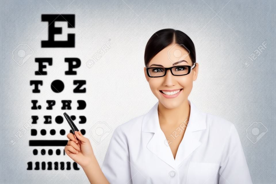 Opticien ou optométriste pointant échelle de Snellen examen de la vue. Ophtalmologiste femme portant des lunettes sur fond blanc. Femme de race blanche / modèle asiatique.