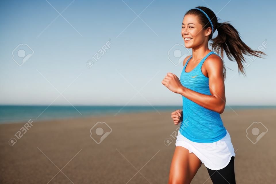 走っている女性。屋外のワークアウト中にビーチでジョギング女性ランナー。美しいフィット混血フィットネス モデル屋外。