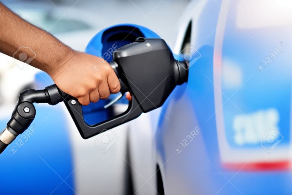 Gas pompen bij gaspomp... close-up van de mens die benzine brandstof pompt in de auto bij benzinestation.