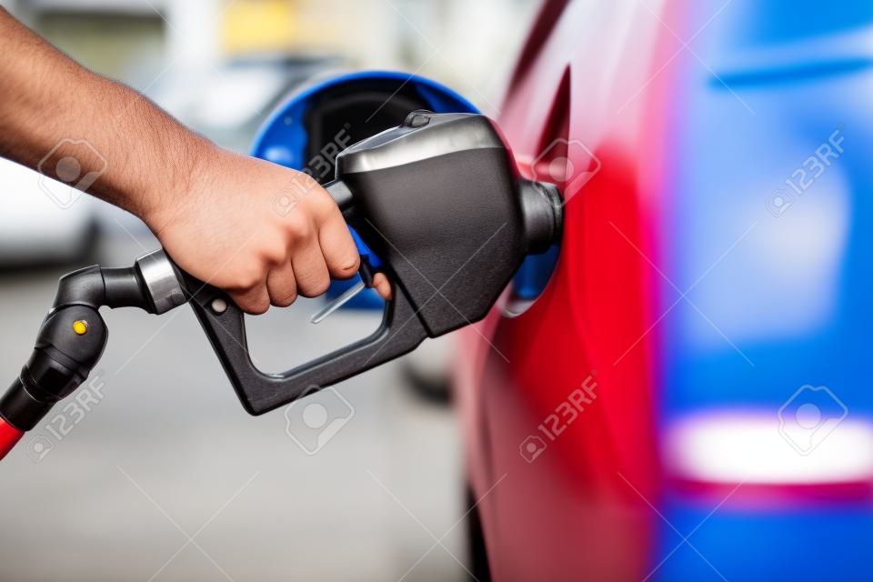 Pumping Gas Zapfsäule. Nahaufnahme des Mannes Pumpen Benzin im Auto an der Tankstelle.