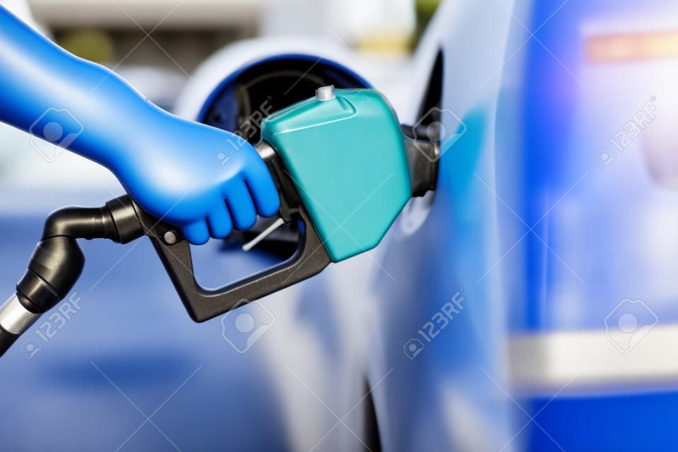 Pumping Gas Zapfsäule. Nahaufnahme des Mannes Pumpen Benzin im Auto an der Tankstelle.