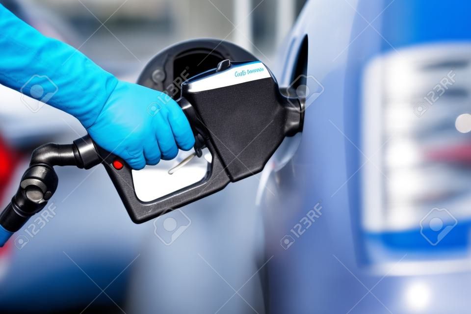 Gas pompen bij gaspomp... close-up van de mens die benzine brandstof pompt in de auto bij benzinestation.