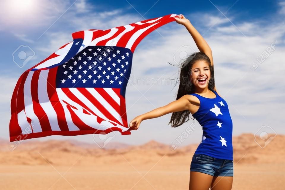 Bandera americana - mujer EE.UU. ganador atleta deporte animando barras y estrellas ondeando al aire libre en la naturaleza después de desierto. Hermosa animando feliz joven multicultural niña alegre y emocionado.