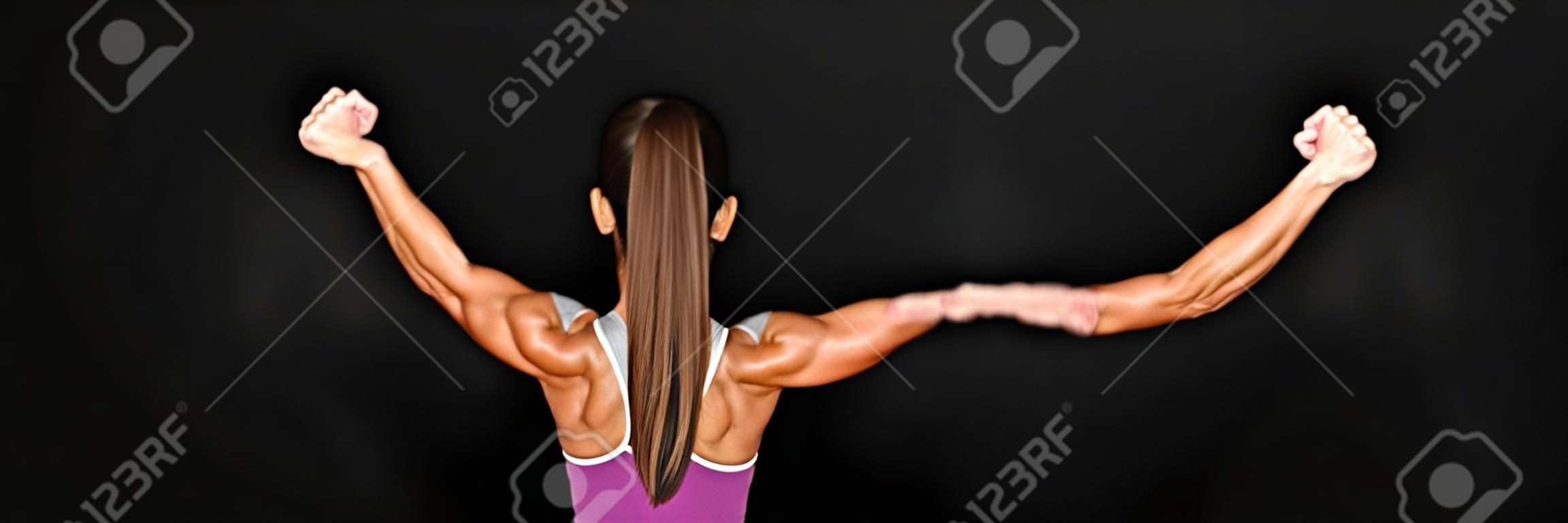 Strong fitness woman showing back and biceps muscles strength. Fit girl fitness model isolated on black background banner panoramic crop for copy space.