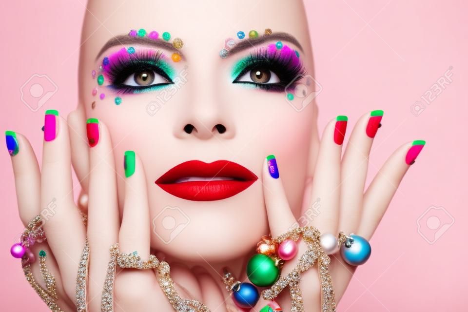 Colorful makeup and manicure with ornaments of different shapes and colors on the blonde girl.
