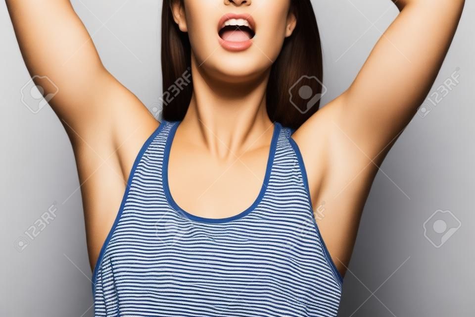 A woman raised her hand to show the hair under her armpits. A natural girl with unshaven armpits. Feminist concept. A woman with a hairy armpit. Body positive. The feminist movement. Depilation