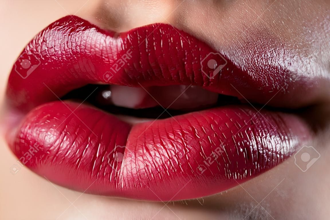Close-up of woman's lips with fashion red make-up. Beautiful female mouth, full lips with perfect makeup. Classic visage. Part of female face. Macro shot of beautiful make up on full lips.