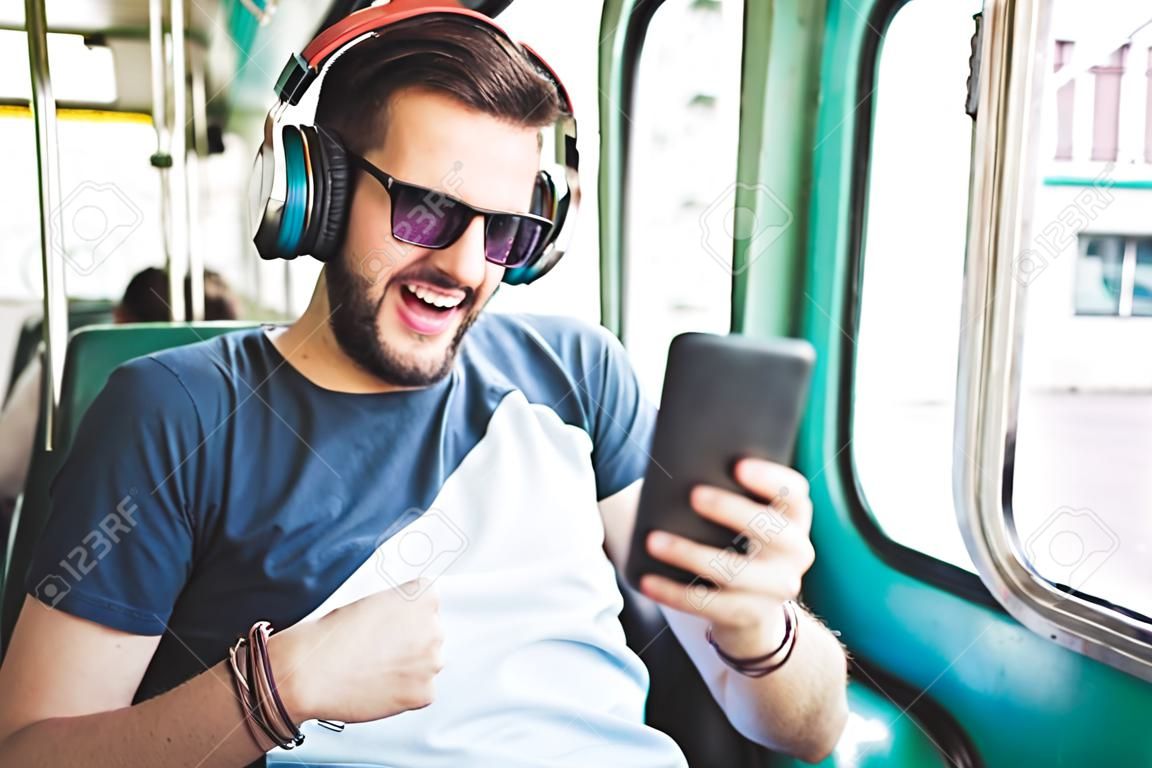 Giovane che ascolta la musica in treno pubblico