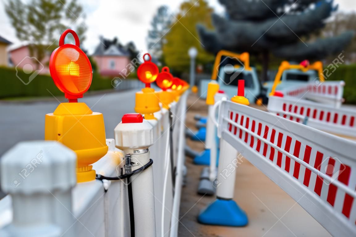 red and white barricades with warning lights at a street in the residential zone, depth of field