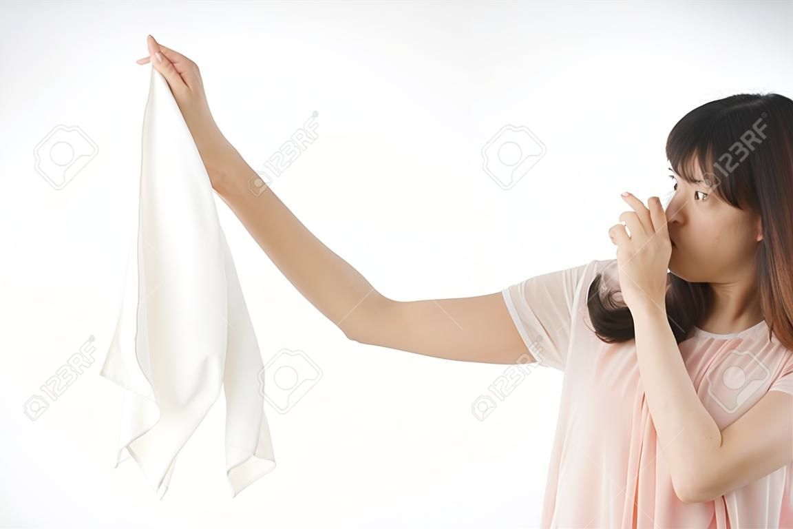 Young woman smelling stinky laundries