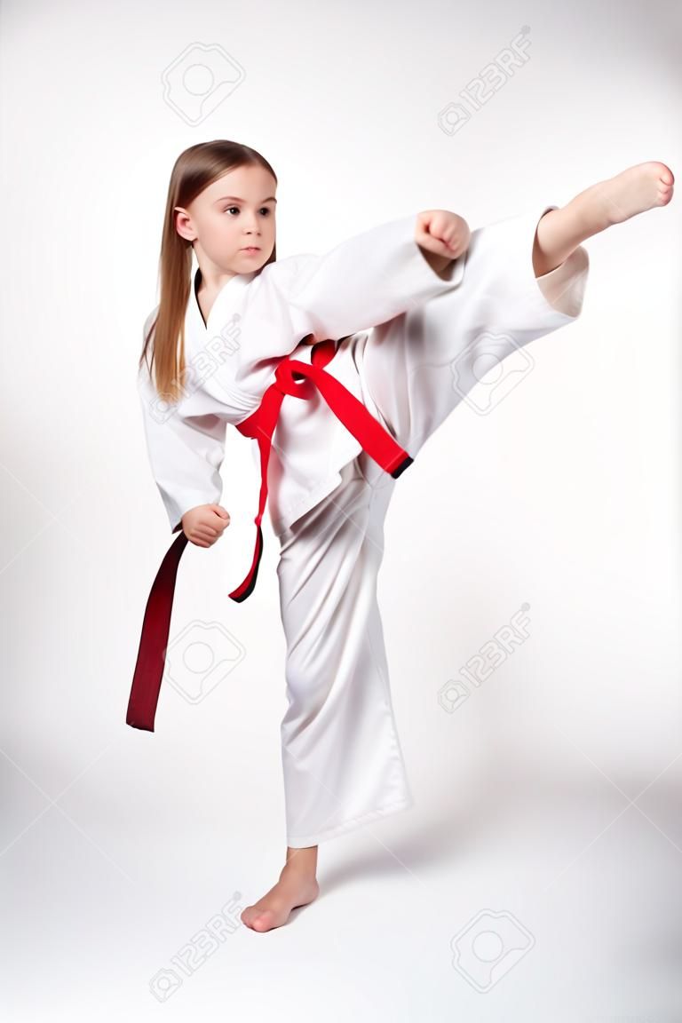 빨간 벨트, 흰색 배경에 고립 발로와 기모노 가라테 소녀