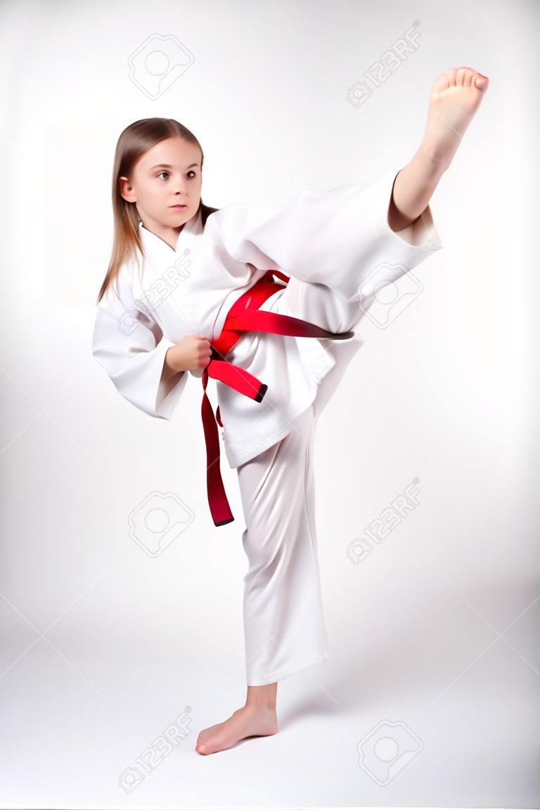 빨간 벨트, 흰색 배경에 고립 발로와 기모노 가라테 소녀