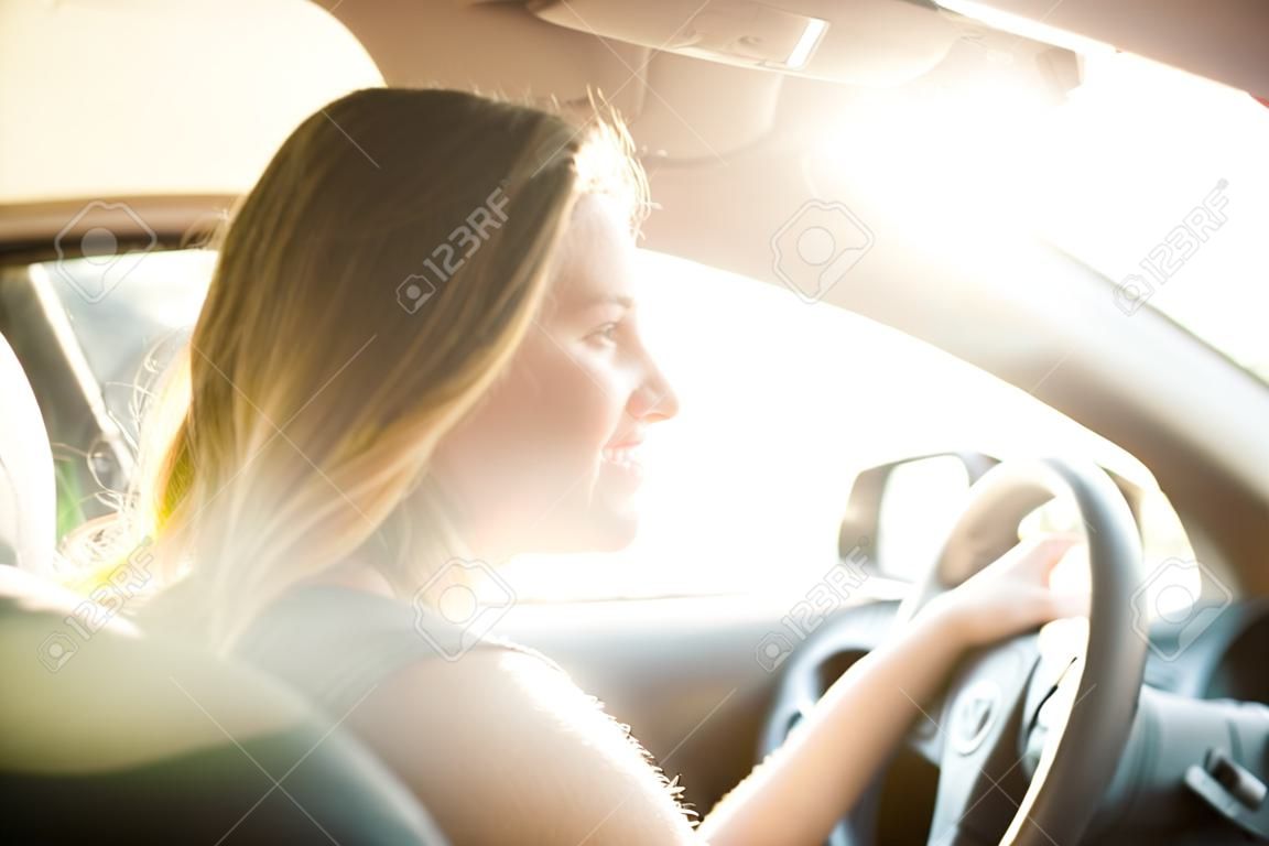 Adolescente voiture conduite - vue arrière, le soleil est visible à travers la fenêtre avant