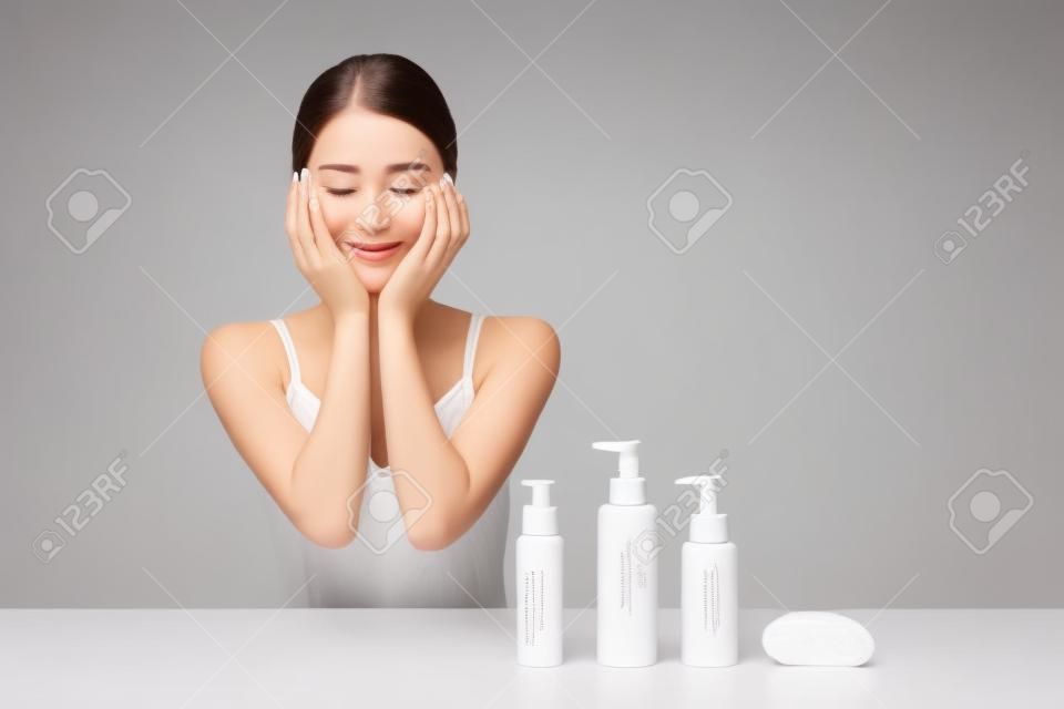 Une bouteille blanche avec une femme qui touche son visage pour les soins de la peau