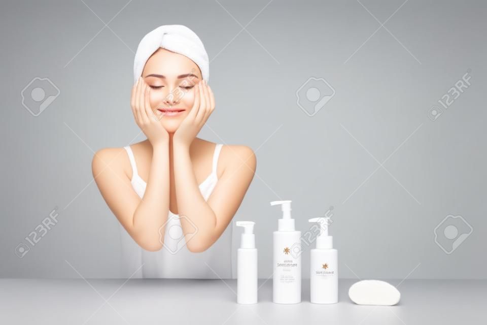 Une bouteille blanche avec une femme qui touche son visage pour les soins de la peau