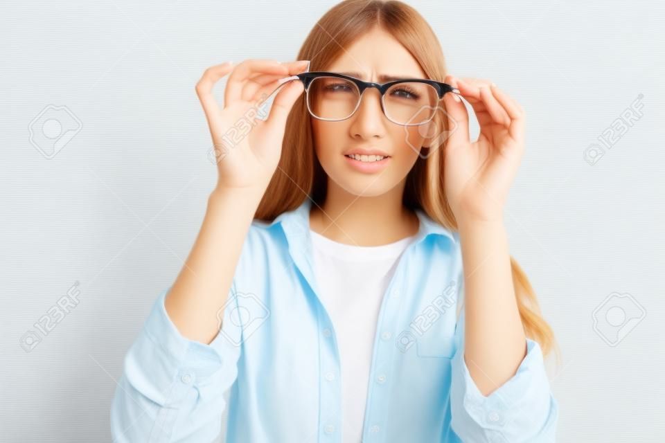 Poor eyesight. Young woman with glasses squinting, trying to take a closer look, woman with poor eyesight on white background