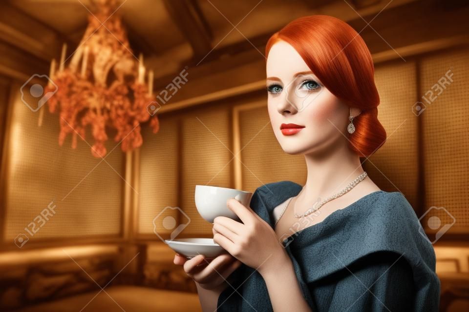 Piękne rude kobiety z filiżanką herbaty. Zdjęcie w starym stylu kolorowego obrazu.