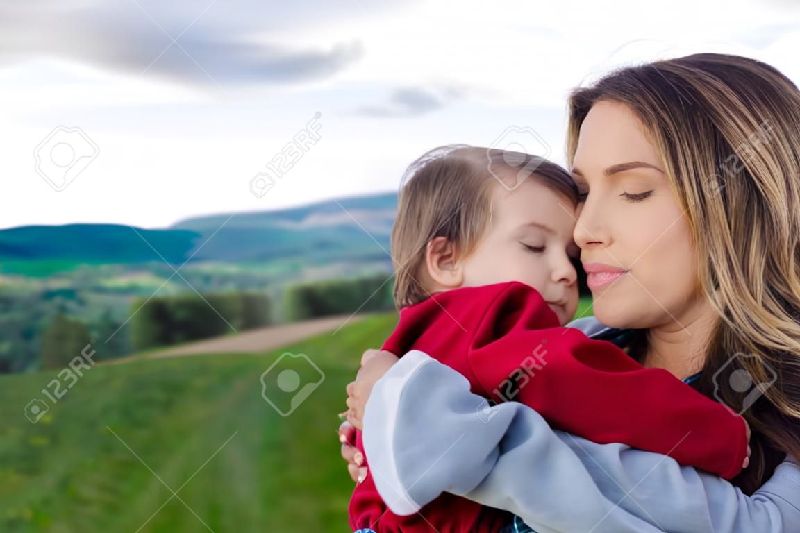 Moeder en peuter jongen hebben een knuffel in een bergen