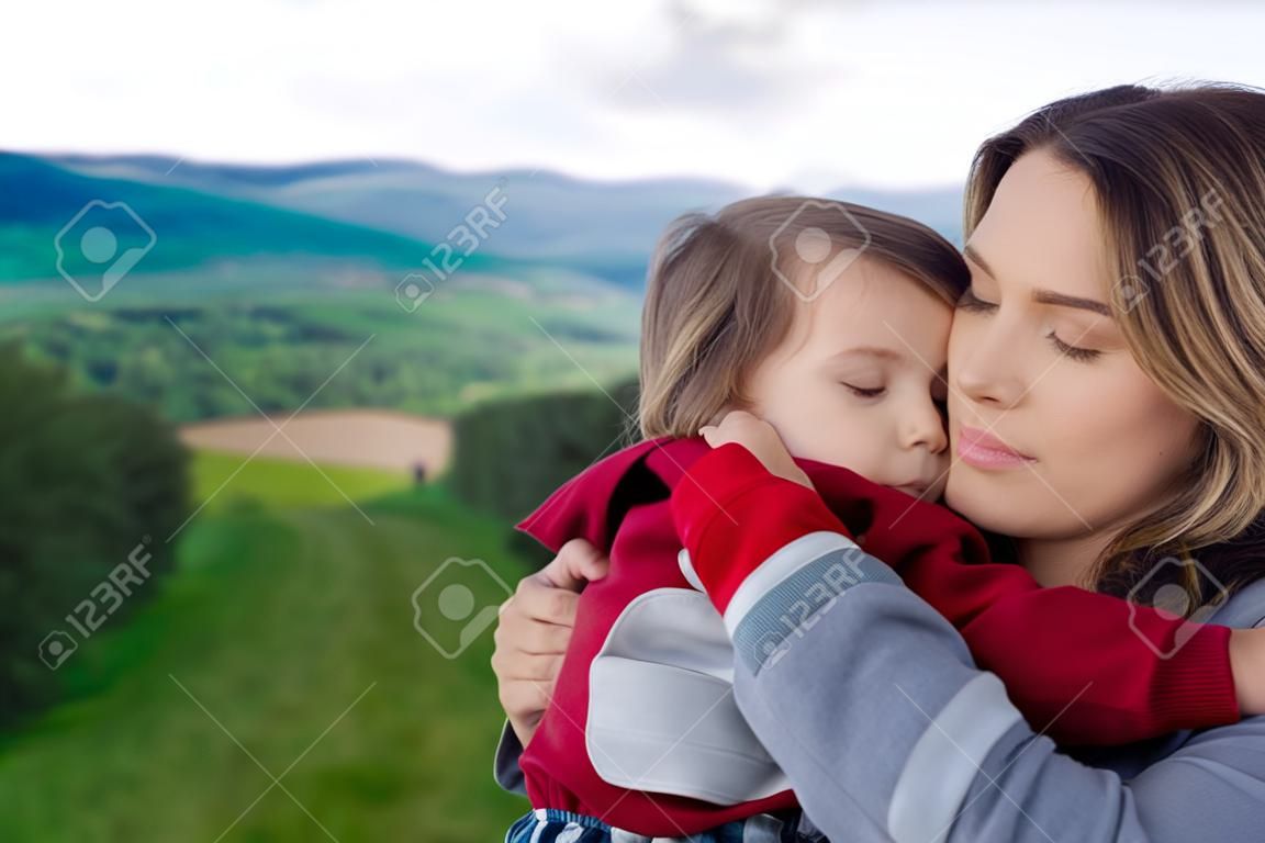 Mother and toddler boy have a hugging in a mountains