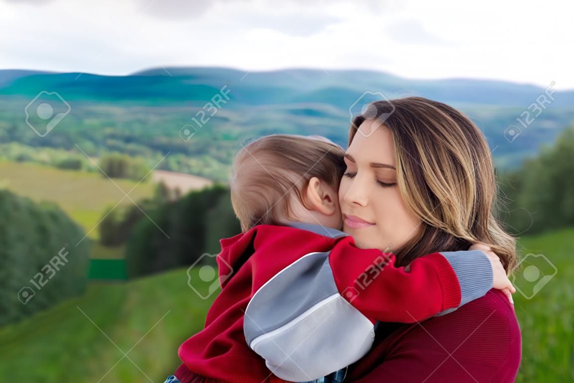 Mãe e menino têm um abraço em uma montanha