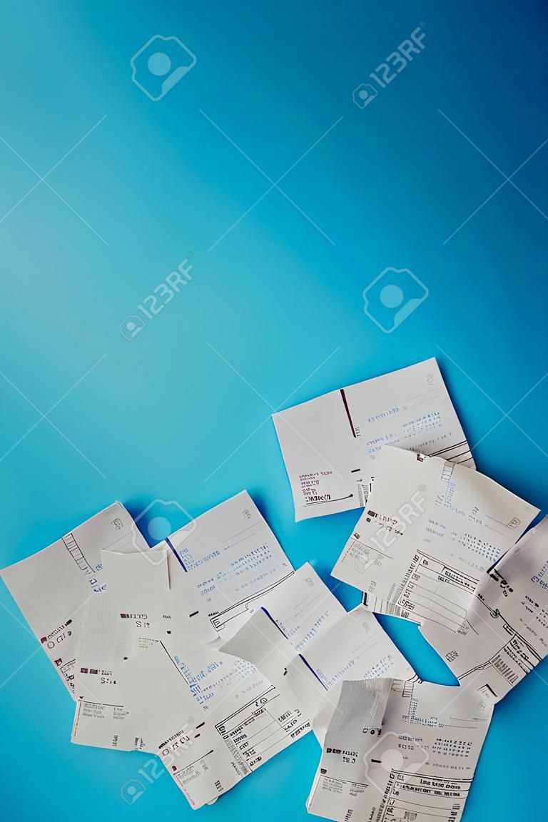 Pile of shopping receipts on a blue background
