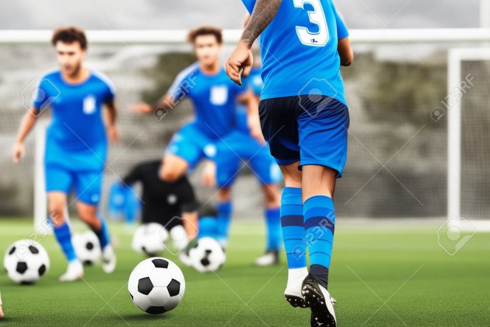Footballer Running with Ball on Training Pitch. Soccer Skills Training Session. Players Training on the Field. Soccer Obstacle Course. Coaching Soccer Gear Equipment for Field Training