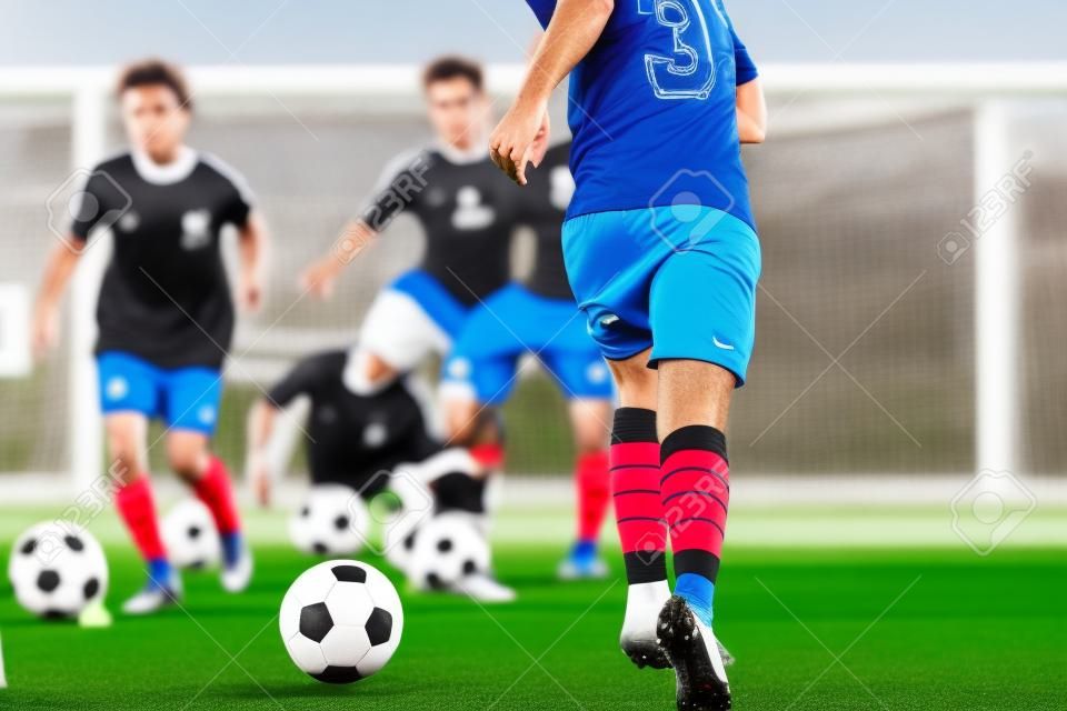 Footballer Running with Ball on Training Pitch. Soccer Skills Training Session. Players Training on the Field. Soccer Obstacle Course. Coaching Soccer Gear Equipment for Field Training
